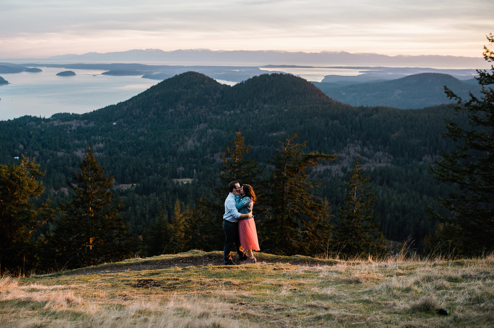 Couple standing on cliff at Orcas Island during a beautiful sunset