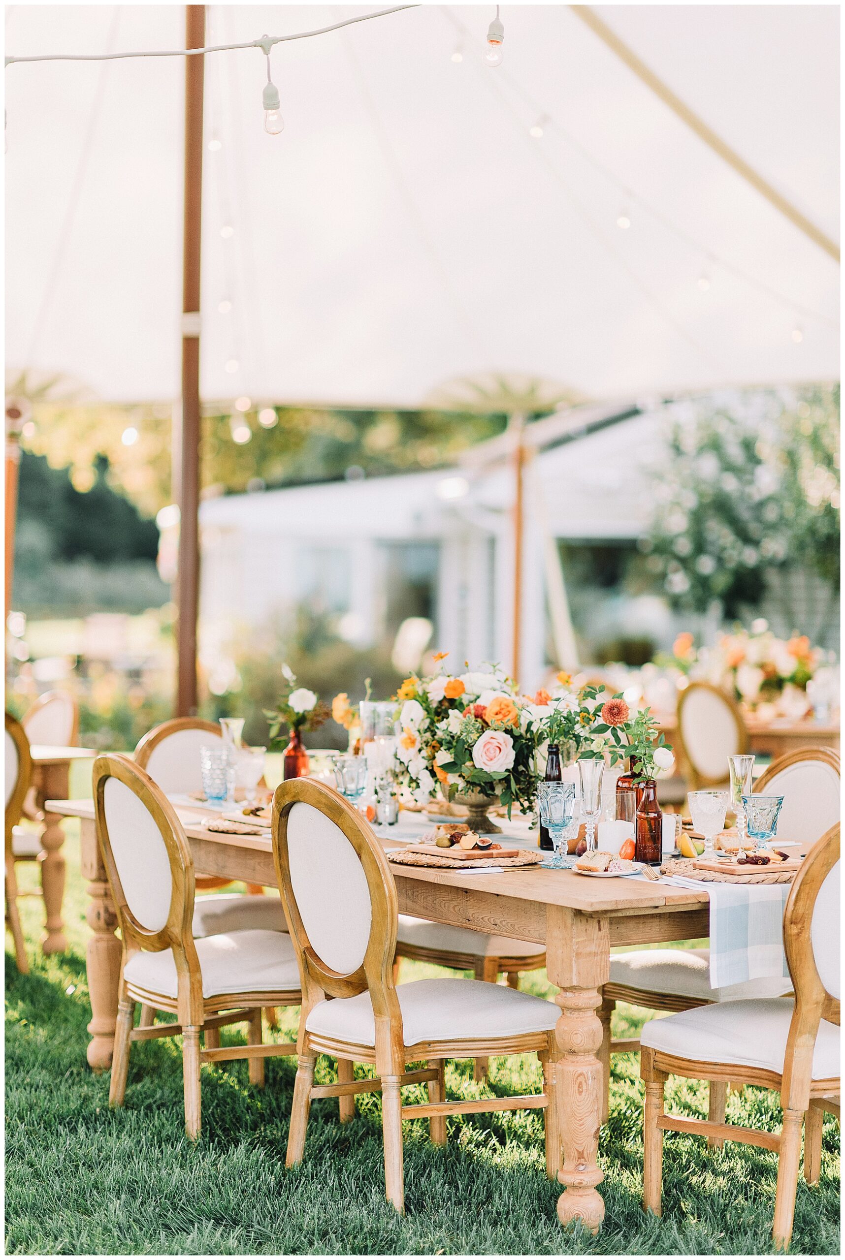 intimate wedding reception tablescape. Lots of lush and cheerful florals under a reception tent.