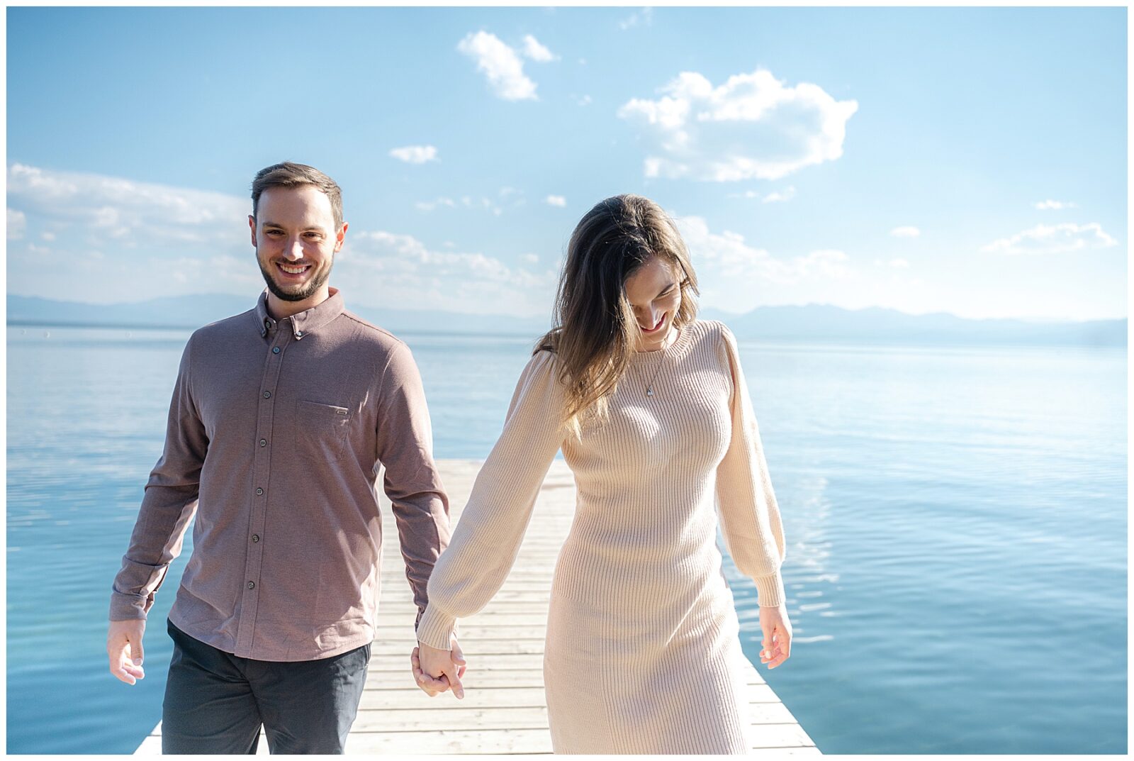 couple laughing and walking down dock during their lake tahoe engagement session