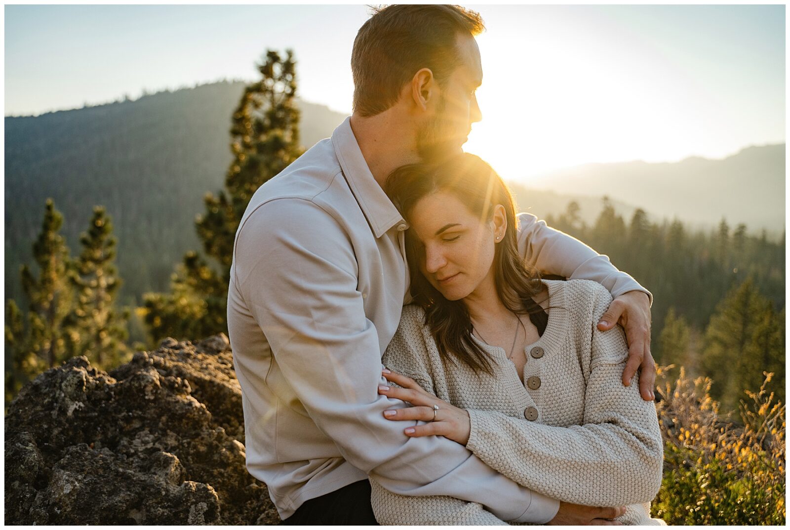 couple sitting on a boulder during sunset during their lake tahoe engagement session