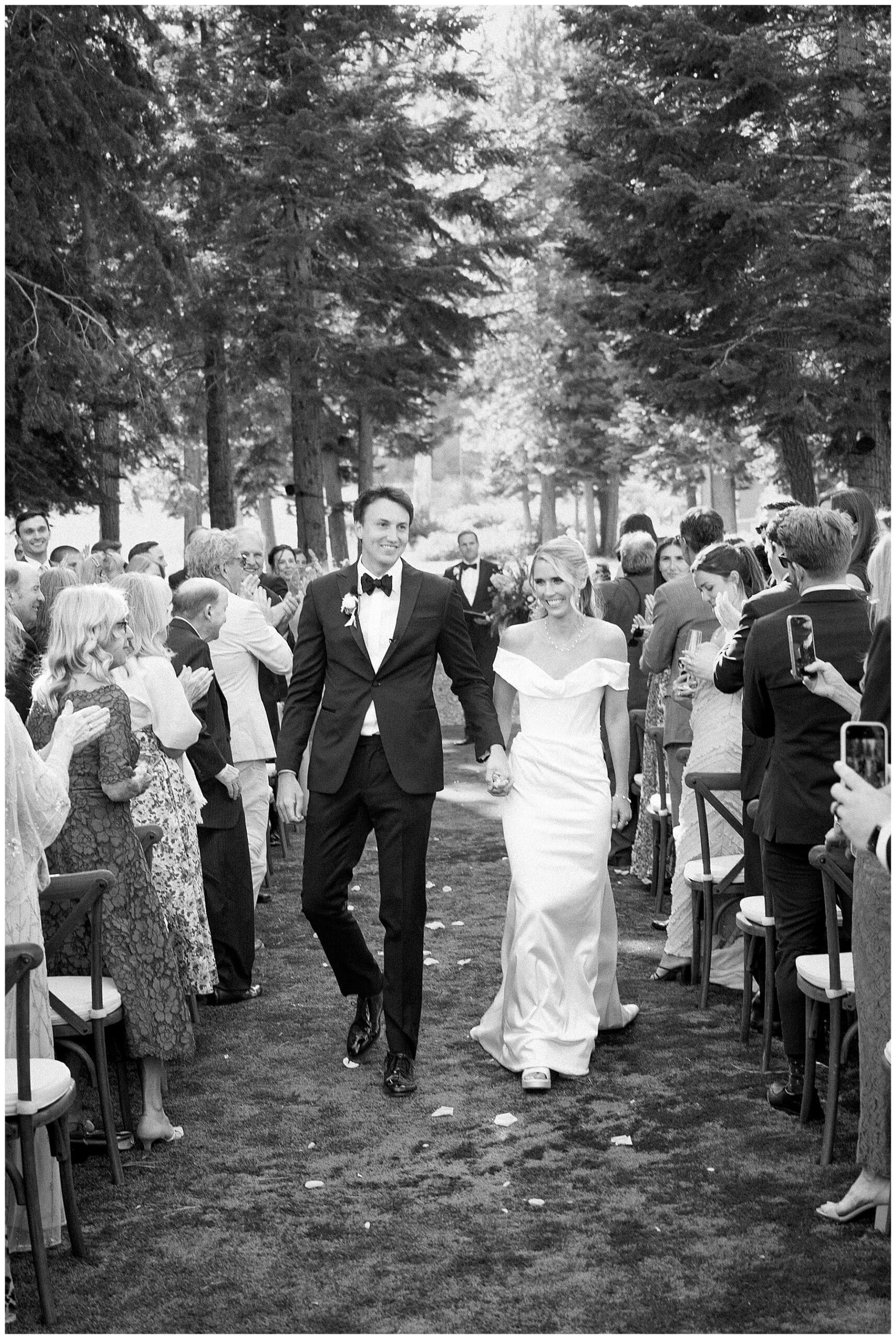 Bride and Groom walking down aisle in The Woods at Ritz-Carlton Lake Tahoe with long veil and floral pedestals